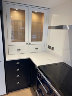 Navy blue & porcelain shaker style kitchen incorporating internal L.E.D glass cabinet lighting , Quartz work tops , Splashback & upstands , Belfast sink with bespoke recessed oak block cutting board , Range cooker & laminate oak effect herringbone flooring