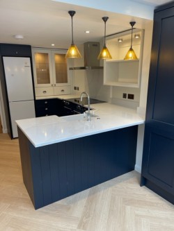 Navy blue & porcelain shaker style kitchen incorporating internal L.E.D glass cabinet lighting , Quartz work tops , Splashback & upstands , Belfast sink with bespoke recessed oak block cutting board , Range cooker & laminate oak effect herringbone flooring