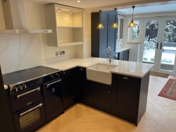 Navy blue & porcelain shaker style kitchen incorporating internal L.E.D glass cabinet lighting , Quartz work tops , Splashback & upstands , Belfast sink with bespoke recessed oak block cutting board , Range cooker & laminate oak effect herringbone flooring