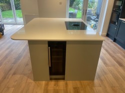 A traditional style wood grained kitchen with a contemporary twist , incorporating quartz worktops , flush recessed ceramic hob , butler style sink with Quooker tap , integrated double ovens , wine fridge housed within the island & stand alone bespoke dresser.